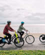 Three women cycling e-bikes along the front in St. Helier Jersey Channel Islands