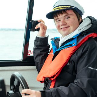 Boy with down syndrome driving a boat